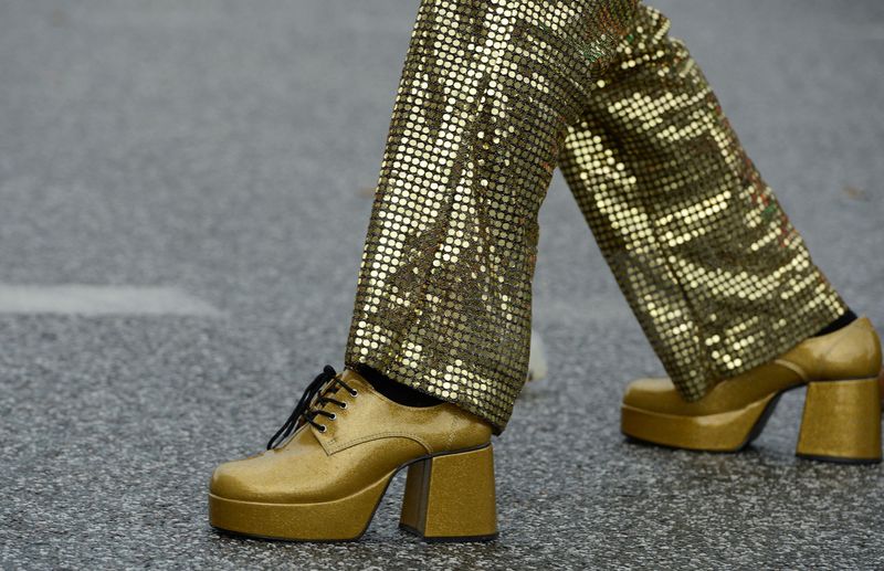 &copy; Reuters. FILE PHOTO: A man wearing 1970s-themed golden shoes and clothes dances on the street during the Schlagermove festival in Hamburg July 7, 2012. REUTERS/Fabian Bimmer/File Photo
