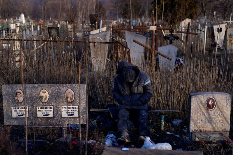 &copy; Reuters. رجل يجلس عند مقبرة في مدينة ماريوبول بأوكرانيا يوم 19 فبراير شباط 2022. رويترز