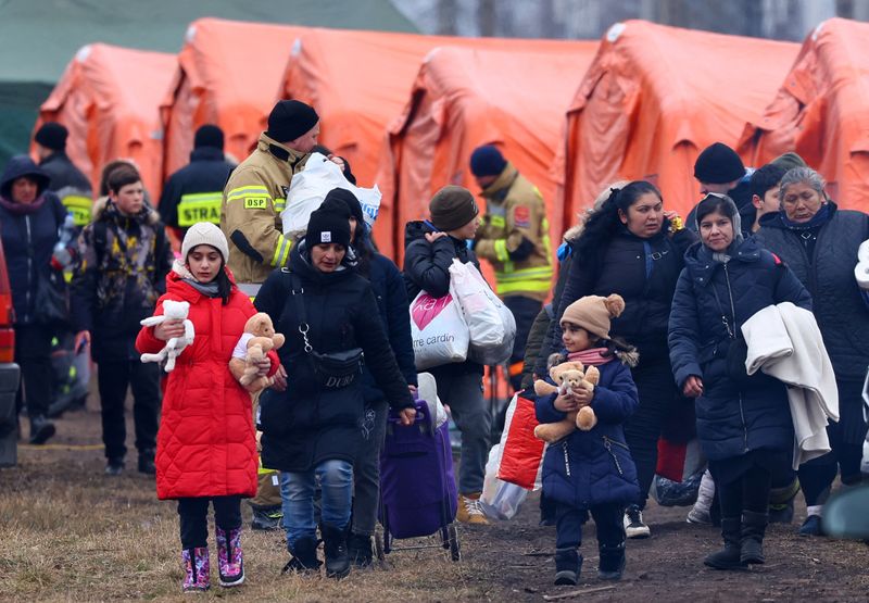 &copy; Reuters. Personas y niños esperan cerca de tiendas de campaña después de cruzar la frontera de Ucrania a Polonia, tras huir de la invasión rusa de Ucrania, en el puesto de control fronterizo de Medyka, Polonia, 10 de marzo de 2022. REUTERS/Fabrizio Bensch