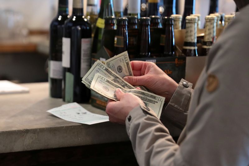 &copy; Reuters. FILE PHOTO: Customers pay cash to buy up stocks of wine, food and kitchen supplies as the French restaurant Montmartre closes after 20 years of operation on Capitol Hill due to financial pressures caused by the coronavirus disease (COVID-19) outbreak in W