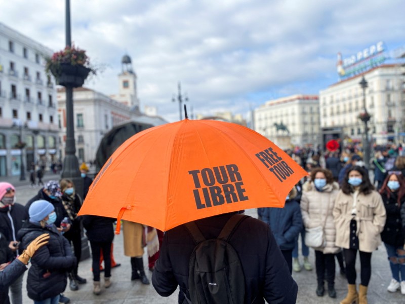 &copy; Reuters. FOTO DE ARCHIVO: Un guía turístico con un paraguas se dirije a un grupo de turistas con mascarilla en la Puerta del Sol de Madrid, España, el 22 de enero de 2022. REUTERS/Nacho Doce