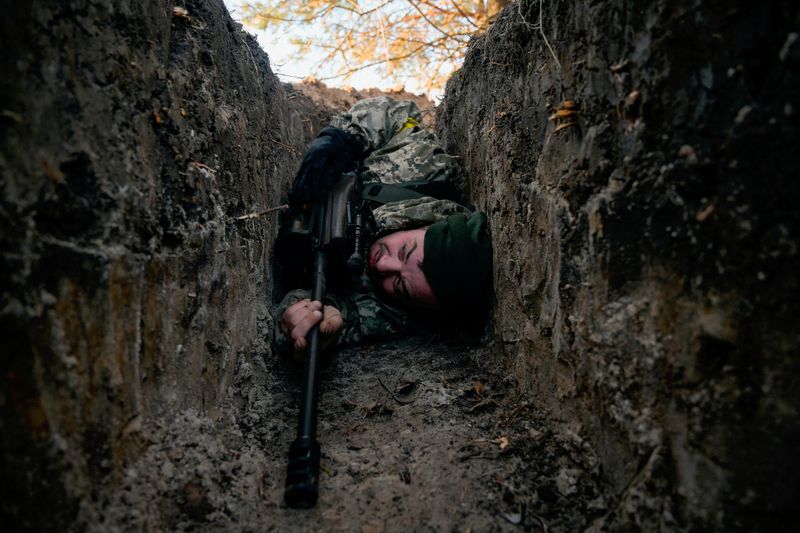 &copy; Reuters. A Ukrainian soldier hides from a helicopter airstrike amid Russia's invasion of Ukraine, near Demydiv, Ukraine March 10, 2022.  REUTERS/Maksim Levin     