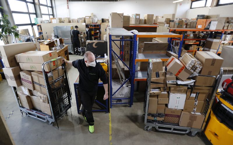 © Reuters. An employee of Lieferadresse Konstanz package reception service moves packages at a branch office in Konstanz, Germany March 4, 2022. REUTERS/Arnd Wiegmann