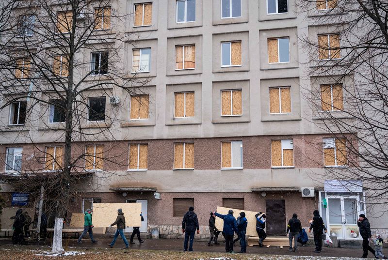 &copy; Reuters. FILE PHOTO: Men use sheets of plywood to cover windows of a hospital following shelling, as Russia's invasion of Ukraine continues, in Zhytomyr, Ukraine March 2, 2022. REUTERS/Viacheslav Ratynskyi/File Photo