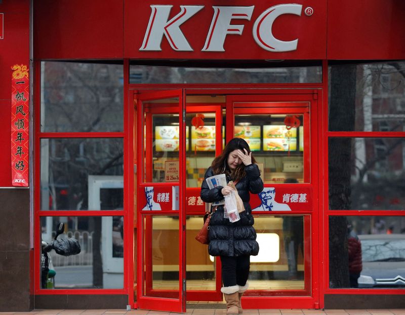© Reuters. FILE PHOTO: A woman walks out a KFC restaurant in Beijing February 25, 2013. REUTERS/Kim Kyung-Hoon/File Photo