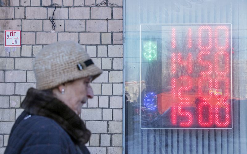 &copy; Reuters. A woman walks past a board showing currency exchange rates of the Euro and the U.S. dollar against the Russian rouble in Moscow, Russia March 11, 2022. REUTERS/Maxim Shemetov