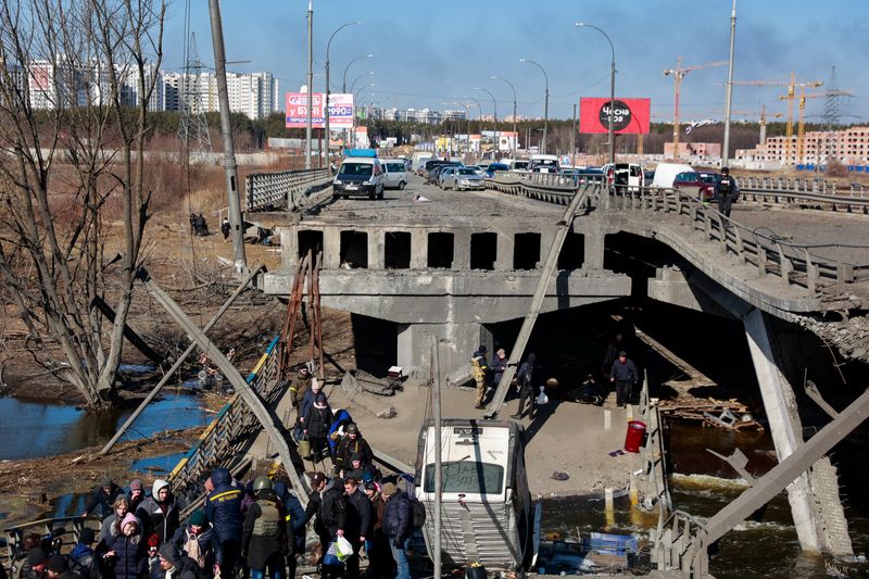 © Reuters. People cross the Irpin river as they evacuate from Irpin town next to a destroyed bridge, amid Russia's invasion of Ukraine, outside of Kyiv, Ukraine March 11, 2022. REUTERS/Serhii Nuzhnenko