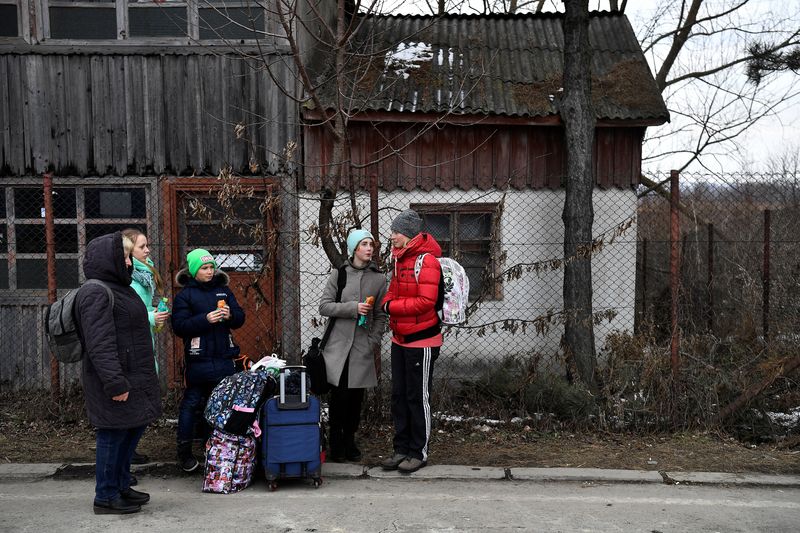 &copy; Reuters. FILE PHOTO: A family wait for transport after fleeing from Ukraine to Romania, following Russia's invasion of Ukraine, at the border crossing in Siret, Romania, March 13, 2022. REUTERS/Clodagh Kilcoyne