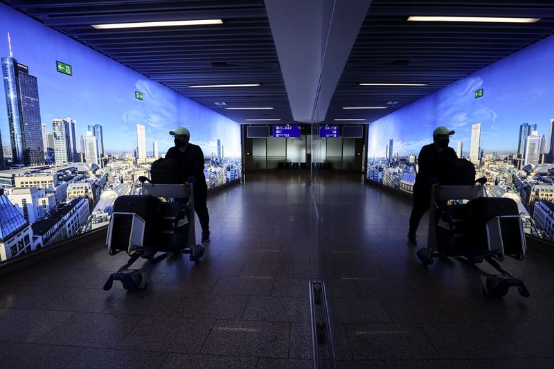 &copy; Reuters. FILE PHOTO: A man pushing a cart is reflected o a mirror as he walks through the corridor at the Frankfurt airport, amid the outbreak of the coronavirus disease (COVID-19), in Frankfurt, Germany, March 29, 2021. REUTERS/Kai Pfaffenbach