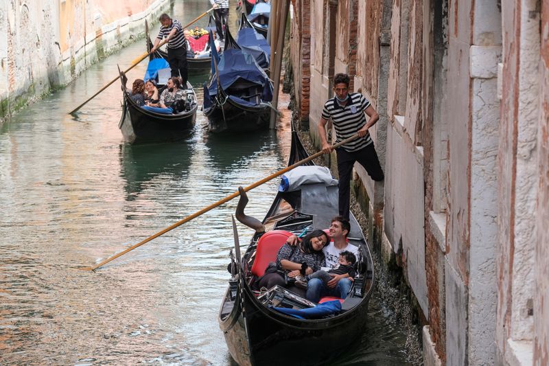 &copy; Reuters. FILE PHOTO: Tourists enjoy a gondola ride as Italy lifts quarantine restrictions for travellers arriving from European Union countries, Britain and Israel and Venice  begins offering COVID-free flights in a bid to revive the tourism industry amid the cor