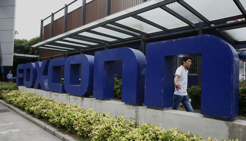 &copy; Reuters. FILE PHOTO: A man walks past a company logo at the entrance to a Foxconn factory in the township of Longhua in the southern Guangdong province May 27, 2010.   REUTERS/Bobby Yip  
