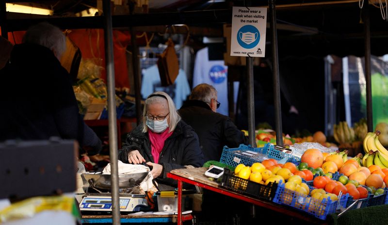 &copy; Reuters. A woman wearing a face mask shops in Cambridge Market Square, amid the coronavirus disease (COVID-19) outbreak, in Cambridge, Britain, January 14, 2022. REUTERS/Andrew Couldridge