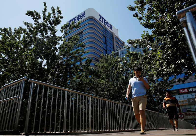 &copy; Reuters. FILE PHOTO: People walk past a building of China's ZTE Corp in Beijing, China, August 29, 2018.  REUTERS/Thomas Peter/File Photo