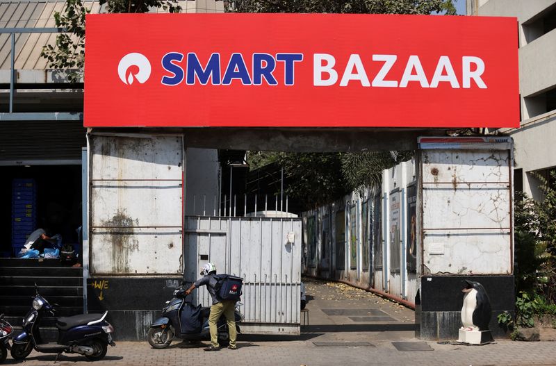 © Reuters. A delivery boy parks his scooter outside a Reliance Smart Bazaar retail store, which was previously Future Retail's Big Bazaar outlet in Mumbai, India, March 14, 2022. REUTERS/Francis Mascarenhas