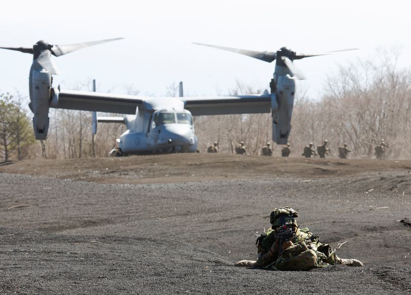 &copy; Reuters. A member of the Japanese Self-Defense Force’s Amphibious Rapid Deployment Brigade takes a position while U.S. Marine Corps members get out of its MV-22 Osprey during a joint airborne landing exercise with the U.S. Marine Corps in Gotemba, west of Tokyo,