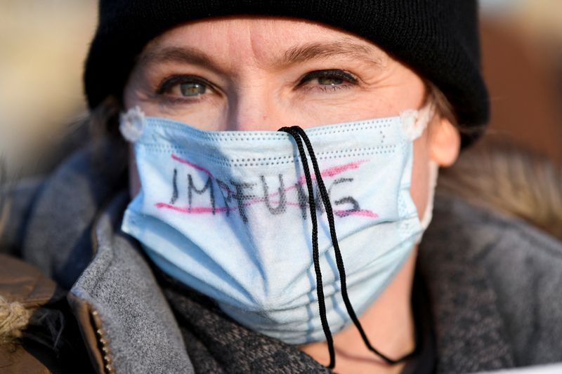 &copy; Reuters. FOTO DE ARCHIVO: Una mujer con una mascarilla en la que aparece la palabra "vacunación" en alemán tachada en rojo durante una protesta contra las restricciones por COVID-19 celebrada en Hamburgo, Alemania, el 12 de marzo de 2022. REUTERS/Fabian Bimmer