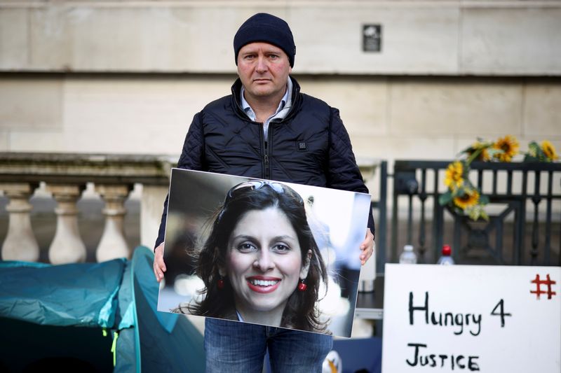 &copy; Reuters. FILE PHOTO: Richard Ratcliffe, husband of British-Iranian aid worker Nazanin Zaghari-Ratcliffe, holds an image of his wife during a second hunger strike, outside the Foreign, Commonwealth and Development Office (FCDO) in London, Britain October 25, 2021. 