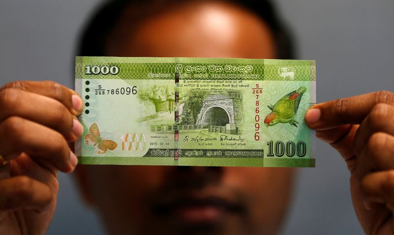 &copy; Reuters. FILE PHOTO: A man shows a thousand rupee note in this illustration photo taken September 7, 2018. REUTERS/Dinuka Liyanawatte/Illustration