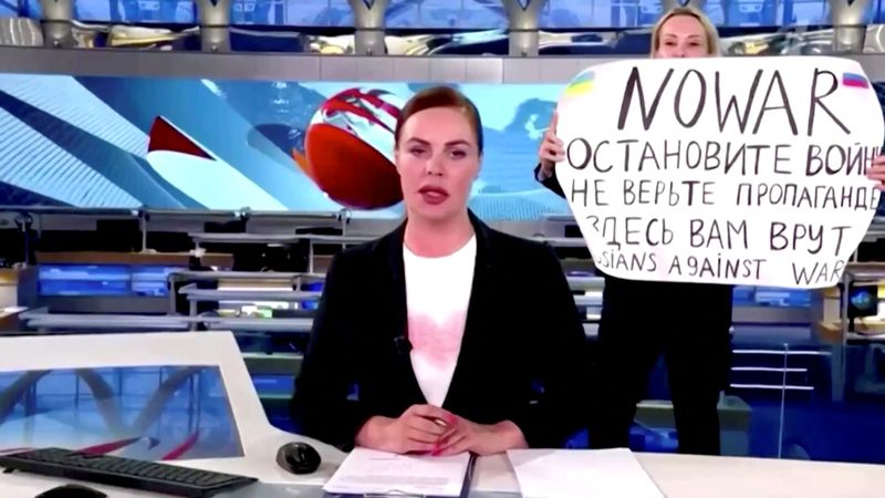 &copy; Reuters. Momento en el que una persona irrumpe en el encuadre de cámara con una pancarta en la que se lee "No a la guerra" en inglés seguido del texto en ruso "Detened la guerra. No se crean la propaganda. Les están mintiendo aquí", durante la emisión del not