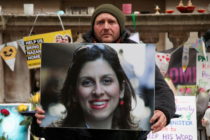 © Reuters. FILE PHOTO: Richard Ratcliffe, husband of British-Iranian aid worker Nazanin Zaghari-Ratcliffe, holds Nazanin's picture during the 19th day of a hunger strike outside the Foreign, Commonwealth and Development Office (FCDO), in London, Britain, November 11, 2021. REUTERS/Peter Cziborra