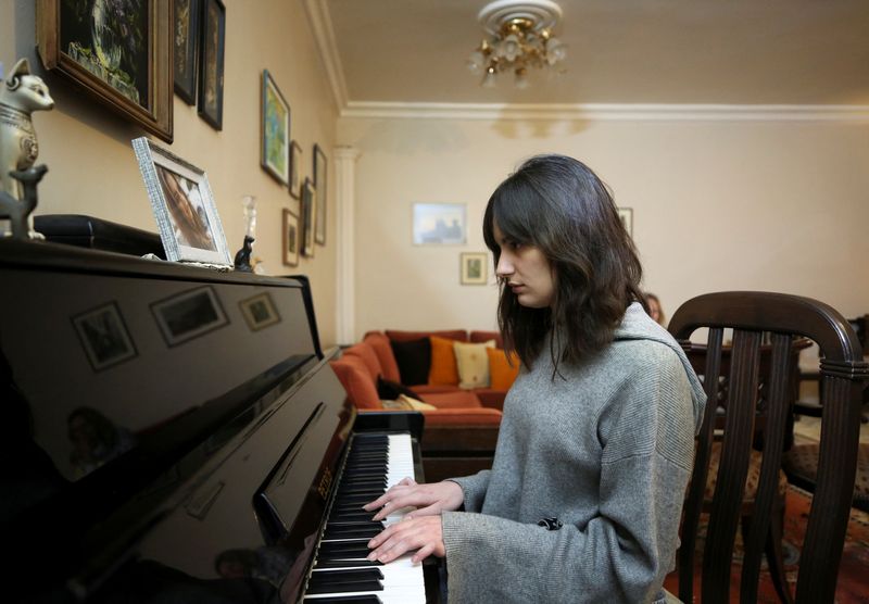 &copy; Reuters. فيكتوريا ناجي، المولودة في سوريا لأب فلسطيني وأم أوكرانية تعزف على البيانو في منزلها في دمشق يوم 12 مارس آذار 2022. تصوير: يمام الشاعر - رويترز