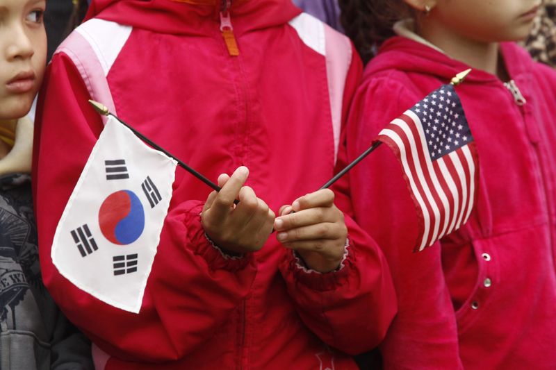 &copy; Reuters. FILE PHOTO: A child holds U.S. and South Korean flags prior to the state arrival of South Korean President Lee Myung-bak at the White House in Washington, October 13, 2011.  REUTERS/Kevin Lamarque 