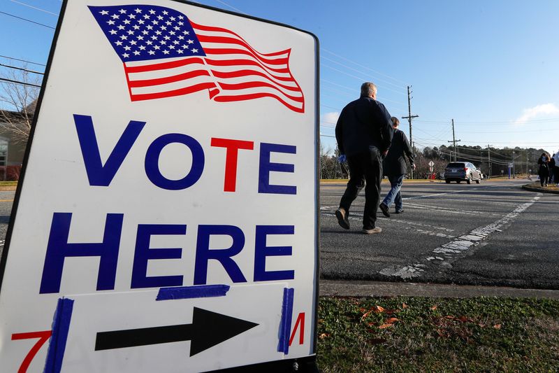 © Reuters. A sign is seen as voters line up for the U.S. Senate run-off election, at a polling location in Marietta, Georgia, U.S., January 5, 2021. REUTERS/Mike Segar 