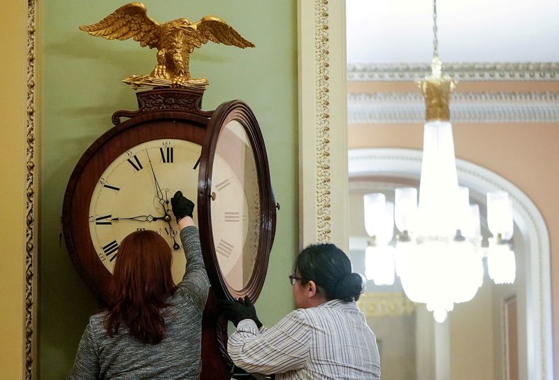 © Reuters. FILE PHOTO: Employees with the Architect of the Capitol wind the Ohio Clock in the U.S. Capitol in Washington, U.S., January 21, 2020. REUTERS/Joshua Roberts