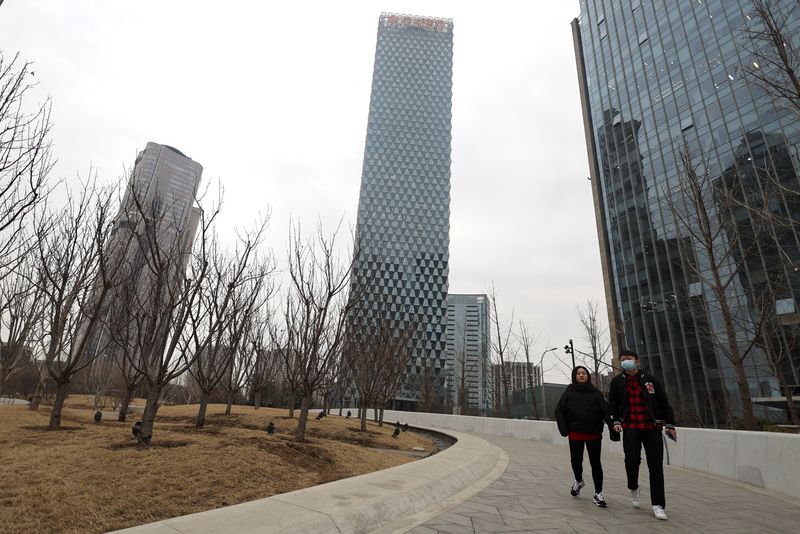 &copy; Reuters. People walk past a building of Greenland Holdings Corp. Ltd. in Beijing, China March 11, 2022. REUTERS/Tingshu Wang