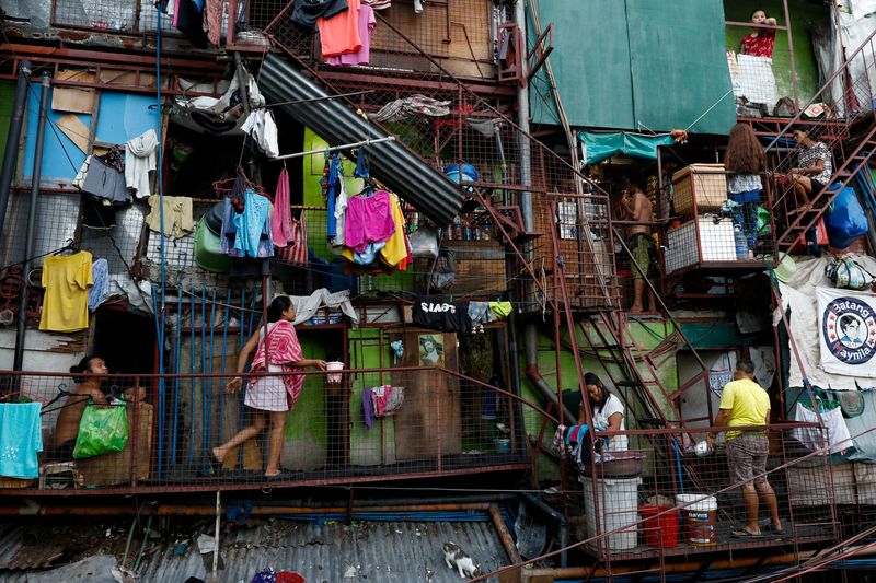 &copy; Reuters. FILE PHOTO: Residents of a small apartment building do house chores outside their units, amid the lockdown to contain the coronavirus disease (COVID-19), in a slum area in Tondo, Manila, Philippines, May 4, 2020. REUTERS/Eloisa Lopez/File Photo