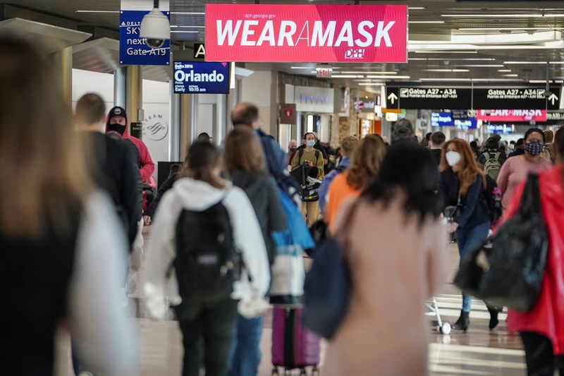 &copy; Reuters. 　３月１５日、米上院は、航空機といった公共交通機関でのマスク着用義務の撤廃を求める決議案を５７対４０の賛成多数で採択した。写真はジョージア州 アトランタの空港で昨年１２月