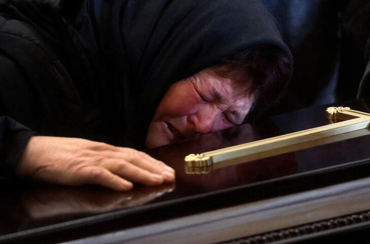 &copy; Reuters. Una mujer llora sobre el féretro de un soldado muero durante la invasión rusa en Leópolis, Ucrania. 15 marzo 2022. REUTERS/Kai Pfaffenbach