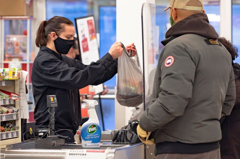 &copy; Reuters. FILE PHOTO: A cashier wearing a mask to help slow the spread of coronavirus disease (COVID-19) bags groceries as the territory of Nunavut enters a two week mandatory restriction period in Iqaluit, Nunavut, Canada November 18, 2020.  REUTERS/Natalie Maerzl