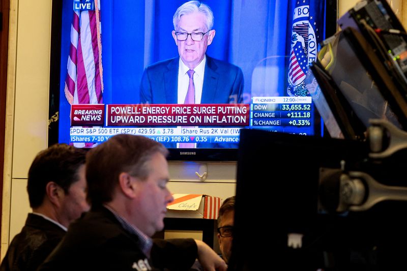 © Reuters. Traders work, as Federal Reserve Chair Jerome Powell is seen delivering remarks on a screen at the New York Stock Exchange (NYSE) in New York City, U.S., March 16, 2022.  REUTERS/Brendan McDermid