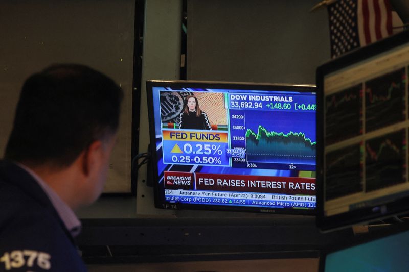© Reuters. A screen displays the Fed rate announcement as traders work on the floor of the New York Stock Exchange (NYSE) in New York City, U.S., March 16, 2022.  REUTERS/Brendan McDermid