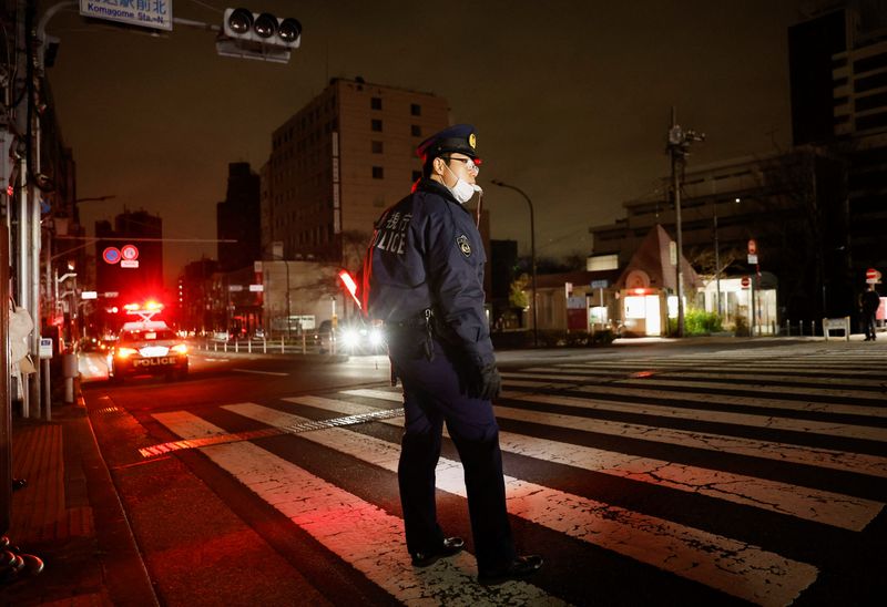 © Reuters. Policial organiza o tráfego de veículos em rua de Tóquio após terremoto cortar energia
17/03/2022
REUTERS/Issei Kato