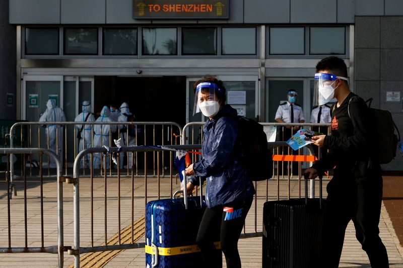 &copy; Reuters. FILE PHOTO: Travellers wearing face mask and shield, walk at the China-Hong Kong border of Shenzhen Bay Port, during the coronavirus disease (COVID-19) pandemic in Hong Kong, China, March 14, 2022. REUTERS/Tyrone Siu/File Photo