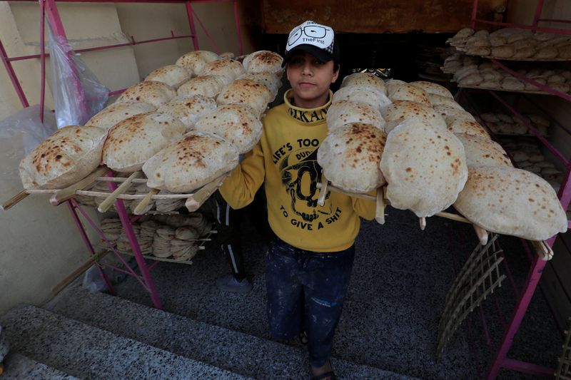 &copy; Reuters. An Egyptian worker carries loaves of bread at a bakery in Cairo's southeastern Mokattam district, as the prices of basic goods in Egypt have risen since Russia?s invasion of Ukraine, in Egypt, March 16, 2022. Picture taken March 16, 2022. REUTERS/Amr Abda