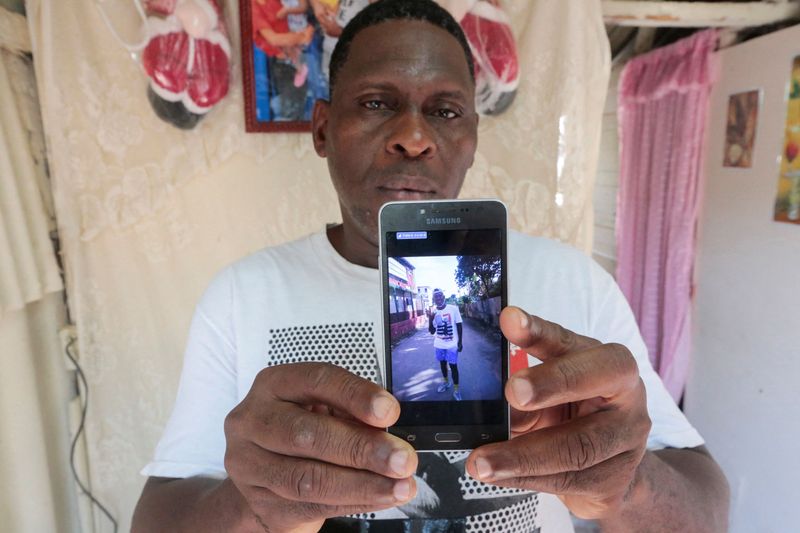 © Reuters. Alcide Firdo, de 47 años, muestra una foto de su hijo Jaime Firdo durante una entrevista con Reuters en La Habana, Cuba. 17 de marzo de 2022. REUTERS/Sringer