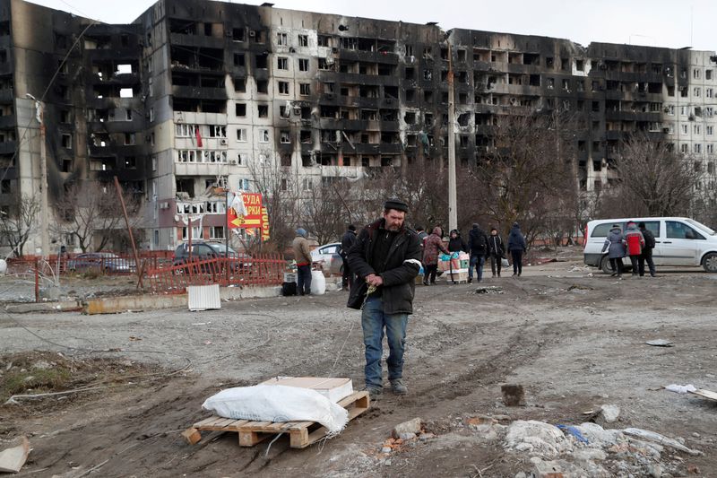 &copy; Reuters. مواطنون يتجمعون عند بناية دمرها القصف الروسي في ماريوبول الأوكرانية يوم الخميس. تصوير ألكسندر إرموتشينكو- رويترز.