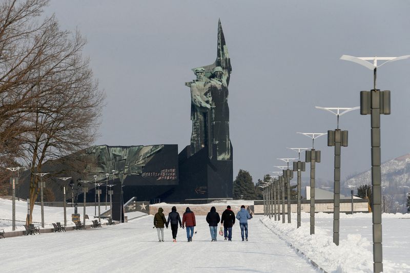 &copy; Reuters. Pessoas caminham perto de monumento em homenagem aos Libertadores do Donbass na cidade dominada pelos rebeldes de Donetsk, na Ucrânia
27/01/2022 REUTERS/Alexander Ermochenko