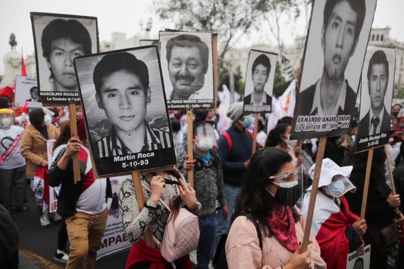 &copy; Reuters. FOTO DE ARCHIVO-Manifestantes sostienen retratos de personas que murieron durante el gobierno del expresidente de Perú, Alberto Fujimori, durante una protesta contra la candidata presidencial de derecha de Perú, Keiko Fujimori. 6 de junio, en Lima, Per