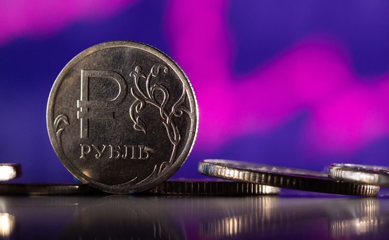 © Reuters. Russian Rouble coins are seen in front of displayed descending stock graph in this illustration taken, February 24, 2022. REUTERS/Dado Ruvic/Illustration