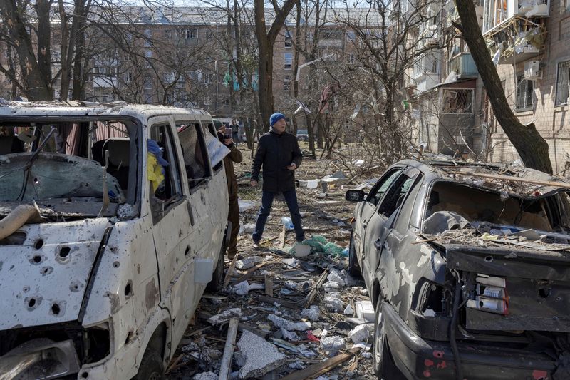 &copy; Reuters. A man walks near destroyed cars in a residential district that was damaged by shelling, as Russia's invasion of Ukraine continues, in Kyiv, Ukraine, March 18, 2022. REUTERS/Marko Djurica    