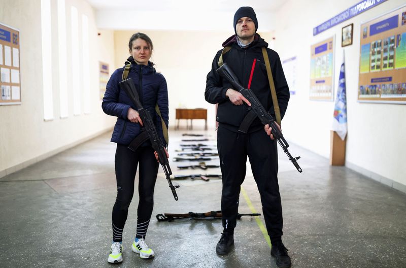 &copy; Reuters. Internet marketing sales manager Maxim Yavtushenko, 32, and his girlfriend, graphic designer Olga Moroz, 26, who volunteered to join the Ukrainian Territorial Defence Forces, pose for a picture during a training session, as Russia's invasion of Ukraine co