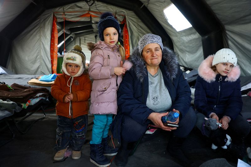 &copy; Reuters. A Ukrainian family from Mykolaiv sit inside a tent to warm up after crossing the border from Ukraine to Poland, fleeing the Russian invasion of Ukraine, at the border checkpoint in Medyka, Poland, March 20, 2022.    REUTERS/Fabrizio Bensch     TPX IMAGES 