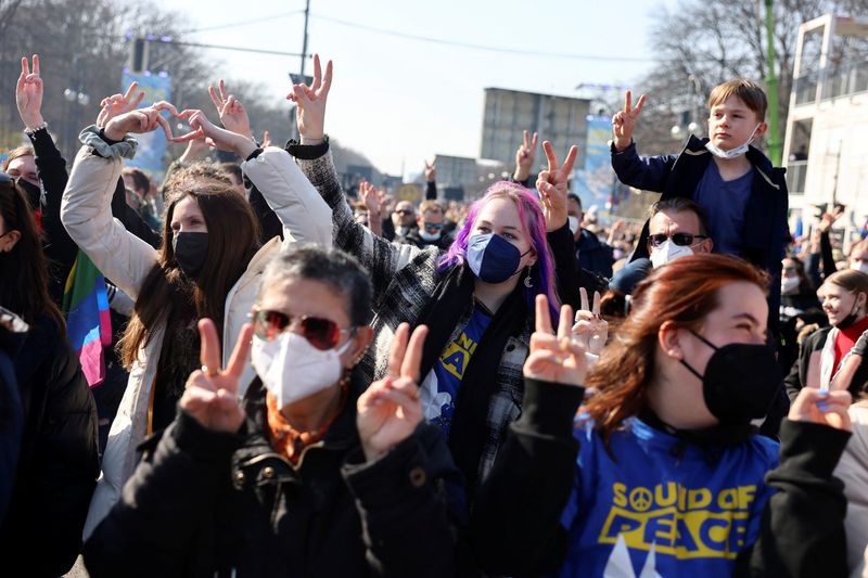 &copy; Reuters. Pessoas fazem sinais de paz com as mãos, no concerto antiguerra "Sound for Peace", em meio à invasão da Ucrânia pela Rússia, no Portão de Brandemburgo, em Berlim, Alemanha, em 20 de março de 2022. REUTERS/Christian Mang