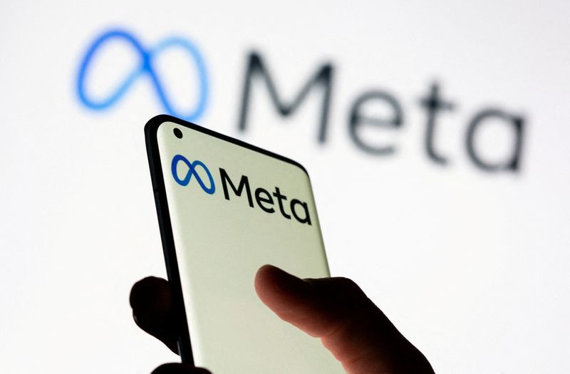 © Reuters. FILE PHOTO: Woman holds smartphone with Meta logo in front of a displayed Facebook's new rebrand logo Meta in this illustration picture taken October 28, 2021. REUTERS/Dado Ruvic/Illustration/File Photo/File Photo