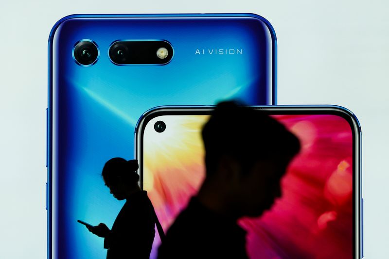 &copy; Reuters. FILE PHOTO: People walk past an advertisement for Huawei's Honor smartphones at an airport in Shenzhen, Guangdong province, China February 27, 2019. REUTERS/Stringer