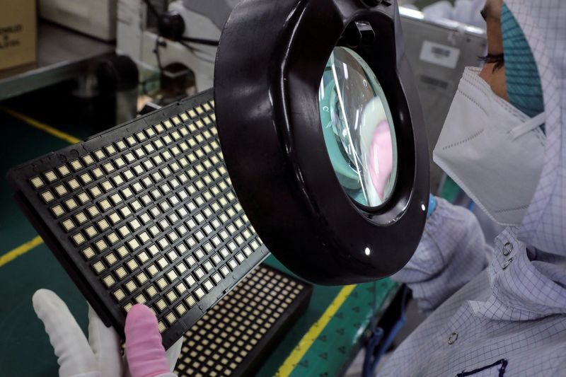 © Reuters. FILE PHOTO: A worker inspects semiconductor chips at the chip packaging firm Unisem (M) Berhad plant in Ipoh, Malaysia October 15, 2021. REUTERS/Lim Huey Teng/File Photo